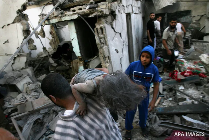Palestinians carry the dead body of a girl who was removed from under the rubble of a house, which witnesses said was destroyed in an Israeli air strike that killed at least nine members from the al-Ghol family, in Rafah...