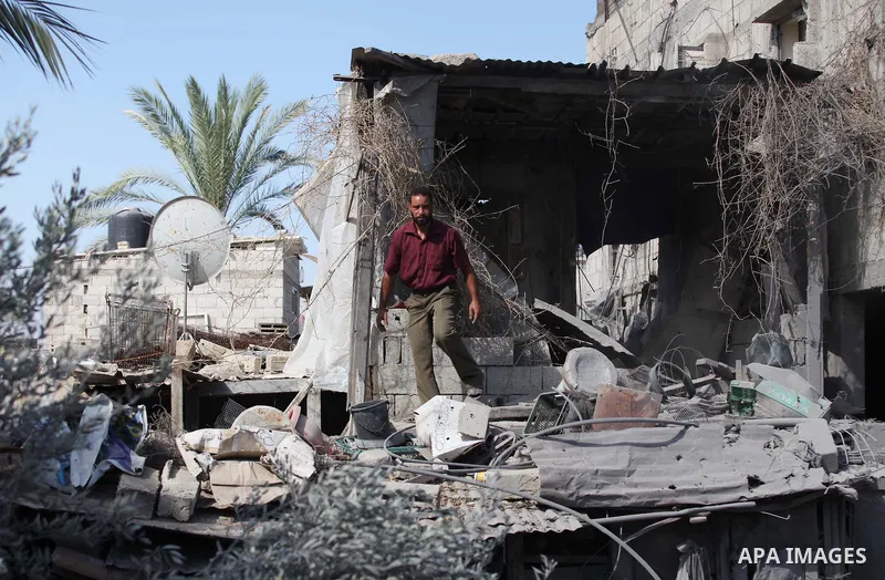 A Palestinian man inspects the rubble of a destroyed house, which witnesses said was destroyed in an Israeli air strike that killed at least five members from the al-Khattab family, in Deir al-Balah in central Gaza Strip...