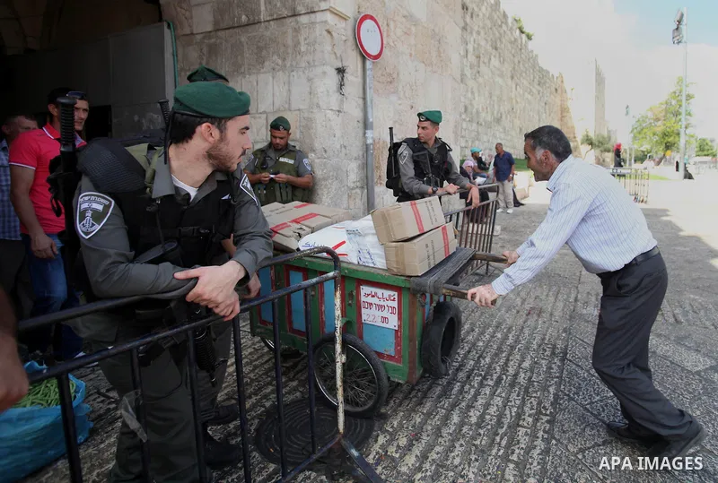 Israeli policemen check documents and belongings of Palestinian worshippers as they preventing them from entering the Al-Aqsa mosque compound in the Old City of Jerusalem on August 3, 2014. Photo by Saeed Qaq