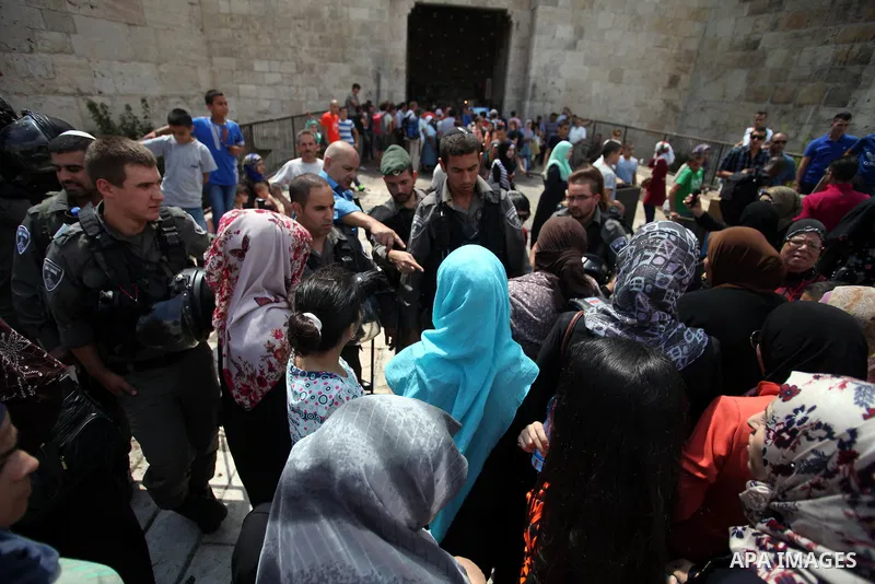 Israeli policemen prevent Palestinian worshippers from entering the Al-Aqsa mosque compound in the Old City of Jerusalem on August 3, 2014. Photo by Saeed Qaq