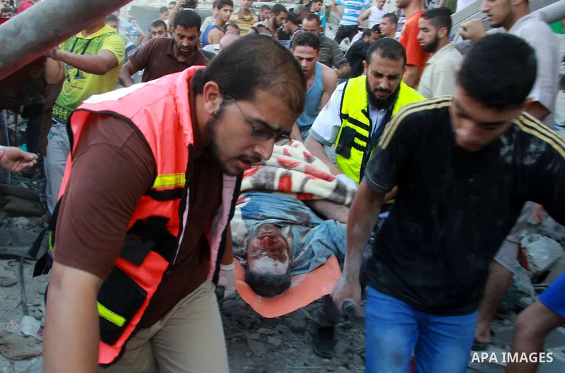 Palestinians evacuate a survivor after an Israeli air strike hit the Al Ghoul family building in Rafah, southern Gaza Strip, Sunday, Aug. 3, 2014. At least 40 people were inside the Al Ghoul family building in Rafah Camp...