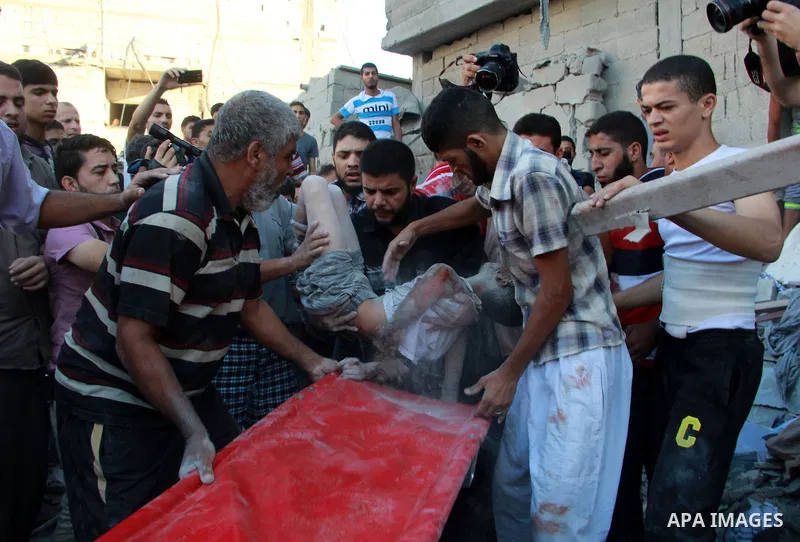 Palestinians evacuate a survivor after an Israeli air strike hit the Al Ghoul family building in Rafah, southern Gaza Strip, Sunday, Aug. 3, 2014. At least 40 people were inside the Al Ghoul family building in Rafah Camp...