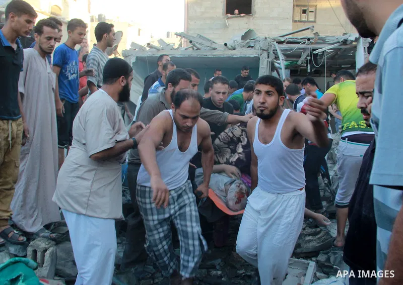 Palestinians evacuate a survivor after an Israeli air strike hit the Al Ghoul family building in Rafah, southern Gaza Strip, Sunday, Aug. 3, 2014. At least 40 people were inside the Al Ghoul family building in Rafah Camp...