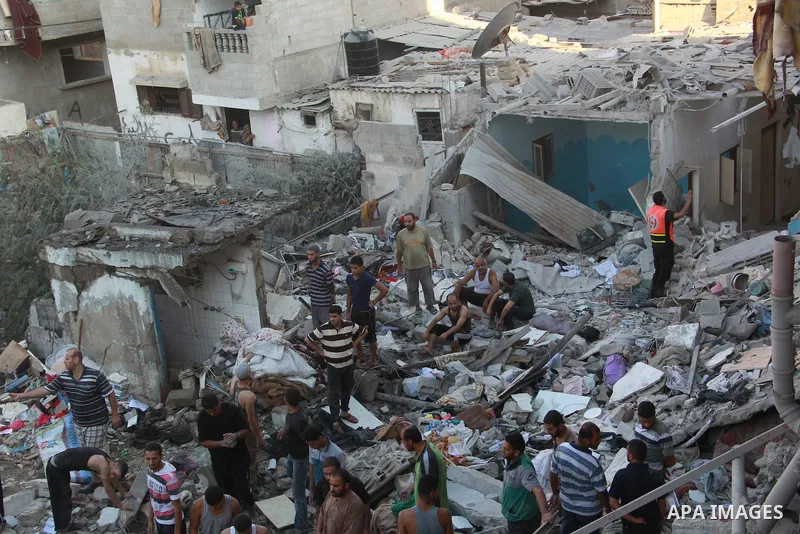 Palestinians evacuate a survivor of an Israeli air strike that hit the Al Ghoul family building in Rafah, southern Gaza Strip, Sunday, Aug. 3, 2014. At least 40 people were inside the Al Ghoul family building in the Rafa...