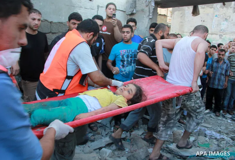 Palestinians evacuate a survivor of an Israeli air strike that hit the Al Ghoul family building in Rafah, southern Gaza Strip, Sunday, Aug. 3, 2014. At least 40 people were inside the Al Ghoul family building in the Rafa...
