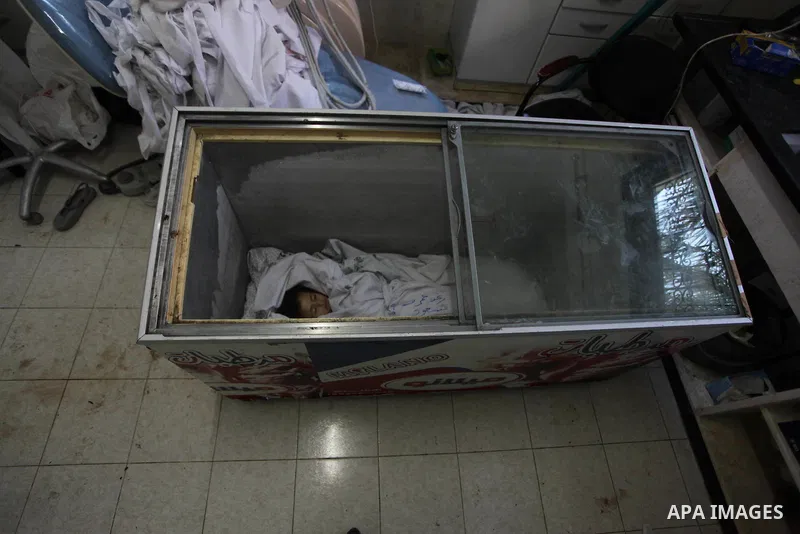 The body of two-and-a-half-year-old Palestinian girl Raghad Massoud, whom medics said was killed in an Israeli air strike, is seen inside an ice-cream freezer at Kuwaiti Hospital, which does not have a morgue, in Rafah i...
