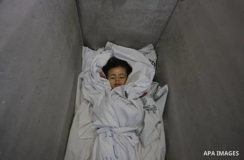 The body of two-and-a-half-year-old Palestinian girl Raghad Massoud, whom medics said was killed in an Israeli air strike, is seen inside an ice-cream freezer at Kuwaiti Hospital, which does not have a morgue, in Rafah i...