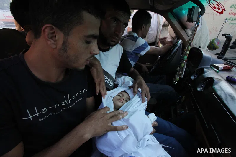 relative sits in a car as he carries the body of two-and-a-half-year-old Palestinian girl Raghad Massoud, whom medics said was killed in an Israeli air strike, before her burial in Rafah in the southern Gaza Strip August...