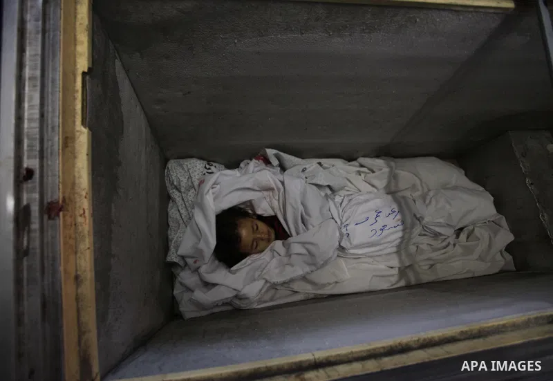 The body of two-and-a-half-year-old Palestinian girl Raghad Massoud, whom medics said was killed in an Israeli air strike, is seen inside an ice-cream freezer at Kuwaiti Hospital, which does not have a morgue, in Rafah i...