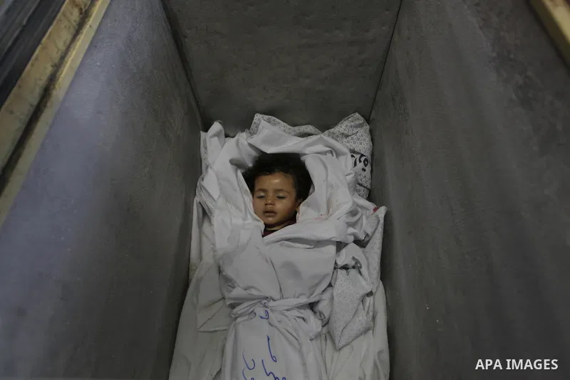 The body of two-and-a-half-year-old Palestinian girl Raghad Massoud, whom medics said was killed in an Israeli air strike, is seen inside an ice-cream freezer at Kuwaiti Hospital, which does not have a morgue, in Rafah i...