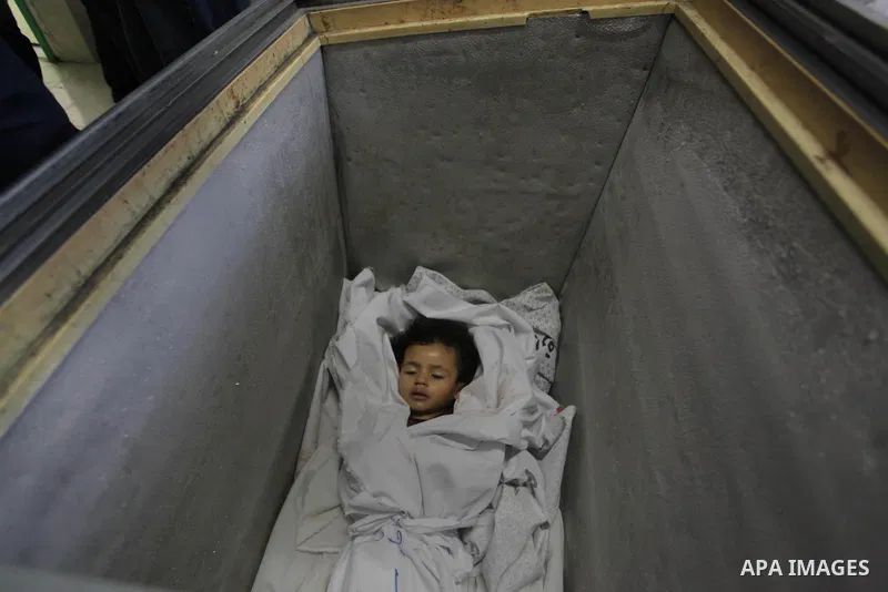 The body of two-and-a-half-year-old Palestinian girl Raghad Massoud, whom medics said was killed in an Israeli air strike, is seen inside an ice-cream freezer at Kuwaiti Hospital, which does not have a morgue, in Rafah i...