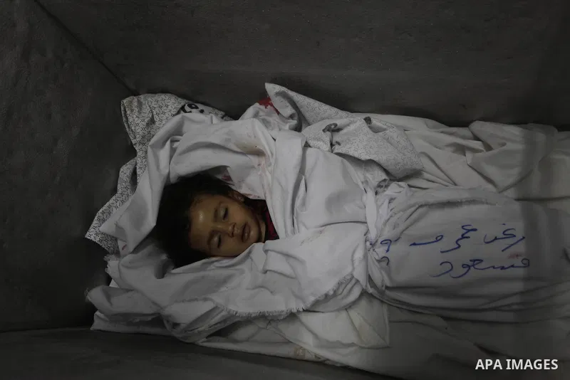 The body of two-and-a-half-year-old Palestinian girl Raghad Massoud, whom medics said was killed in an Israeli air strike, is seen inside an ice-cream freezer at Kuwaiti Hospital, which does not have a morgue, in Rafah i...