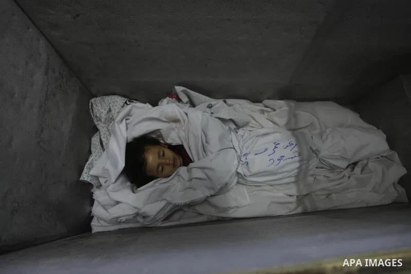 The body of two-and-a-half-year-old Palestinian girl Raghad Massoud, whom medics said was killed in an Israeli air strike, is seen inside an ice-cream freezer at Kuwaiti Hospital, which does not have a morgue, in Rafah i...