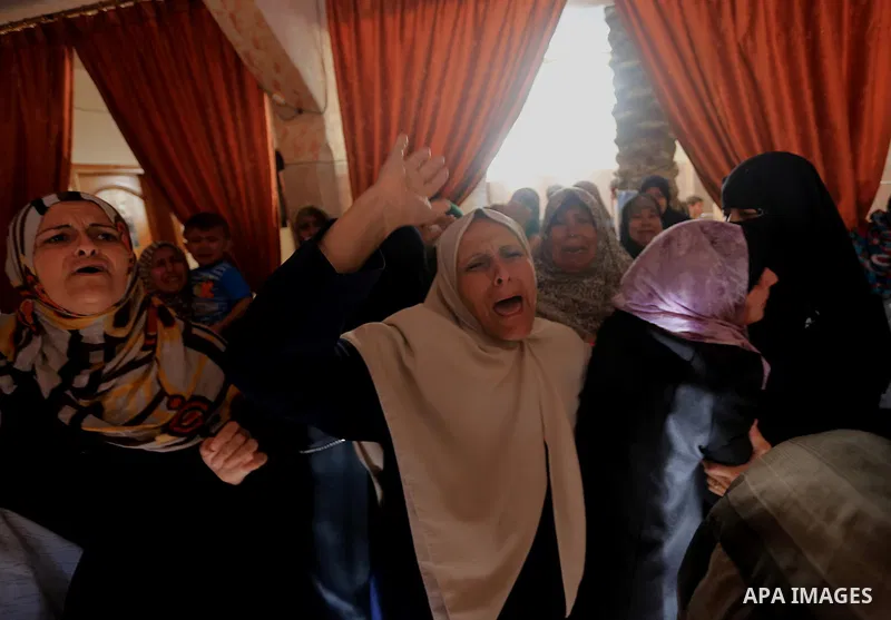 Palestinian relatives mourn on the body of a Palestinian man, Mohammed Shladan, 30, whom medics said was killed in an Israeli air strike on a house, during his funeral in Gaza city August 4, 2014. August 4, 2014. Israel...