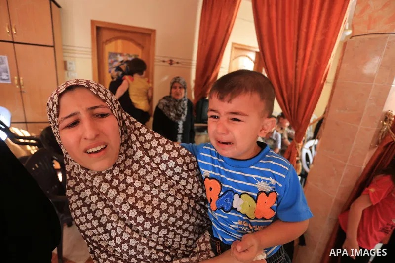 Palestinian relatives mourn on the body of a Palestinian man, Mohammed Shladan, 30, whom medics said was killed in an Israeli air strike on a house, during his funeral in Gaza city August 4, 2014. August 4, 2014. Israel...