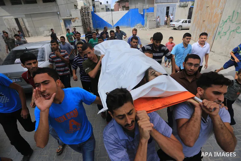 Palestinian relatives carry the body of a Palestinian man, Mohammed Shladan, 30, whom medics said was killed in an Israeli air strike on a house, during his funeral in Gaza city August 4, 2014. August 4, 2014. Israel sai...