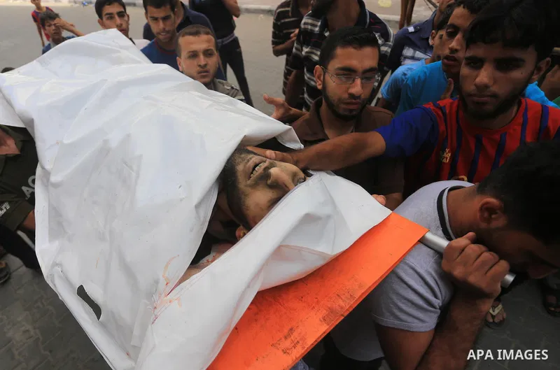 Palestinian relatives carry the body of a Palestinian man, Mohammed Shladan, 30, whom medics said was killed in an Israeli air strike on a house, during his funeral in Gaza city August 4, 2014. August 4, 2014. Israel sai...