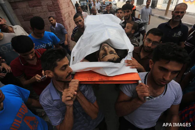 Palestinian relatives carry the body of a Palestinian man, Mohammed Shladan, 30, whom medics said was killed in an Israeli air strike on a house, during his funeral in Gaza city August 4, 2014. August 4, 2014. Israel sai...