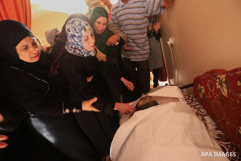 Palestinian relatives mourn over the body of a Palestinian man, Mohammed Shladan, 30, whom medics said was killed in an Israeli air strike on a house, during his funeral in Gaza city August 4, 2014. August 4, 2014. Israe...