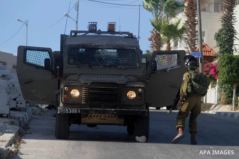 Israeli soldiers stand guard during an operation storm in the West Bank city of Al-Bireh, on August 3, 2014. Photo by Shadi Hatem