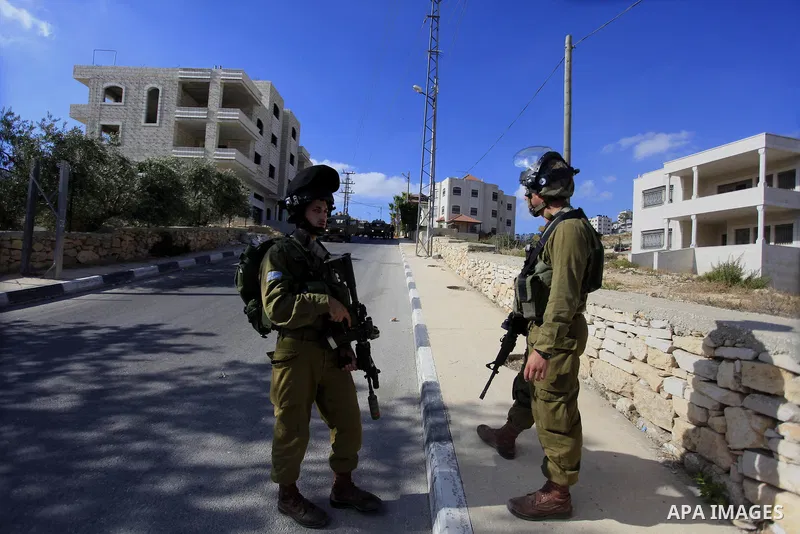 Israeli soldiers stand guard during an operation storm in the West Bank city of Al-Bireh, on August 3, 2014. Photo by Shadi Hatem