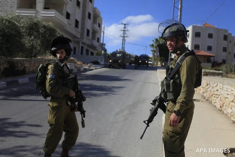 Israeli soldiers stand guard during an operation storm in the West Bank city of Al-Bireh, on August 3, 2014. Photo by Shadi Hatem