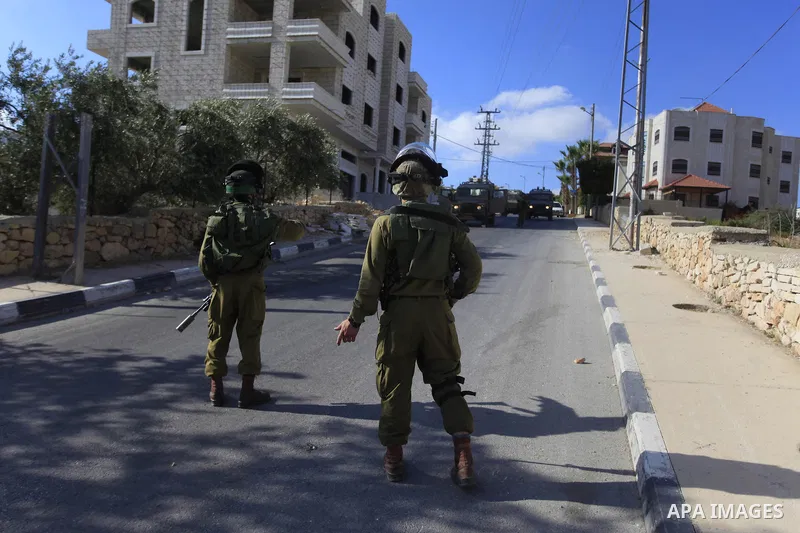 Israeli soldiers stand guard during an operation storm in the West Bank city of Al-Bireh, on August 3, 2014. Photo by Shadi Hatem