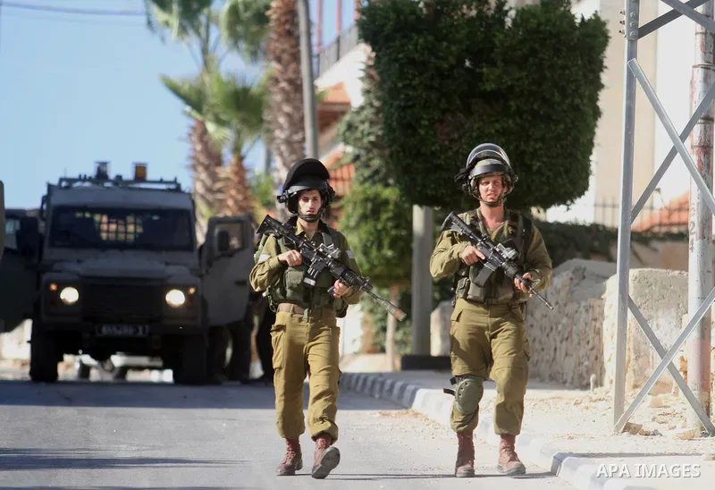 Israeli soldiers stand guard during an operation storm in the West Bank city of Al-Bireh, on August 3, 2014. Photo by Shadi Hatem