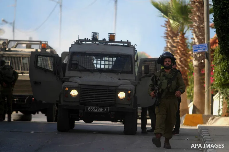 Israeli soldiers stand guard during an operation storm in the West Bank city of Al-Bireh, on August 3, 2014. Photo by Shadi Hatem