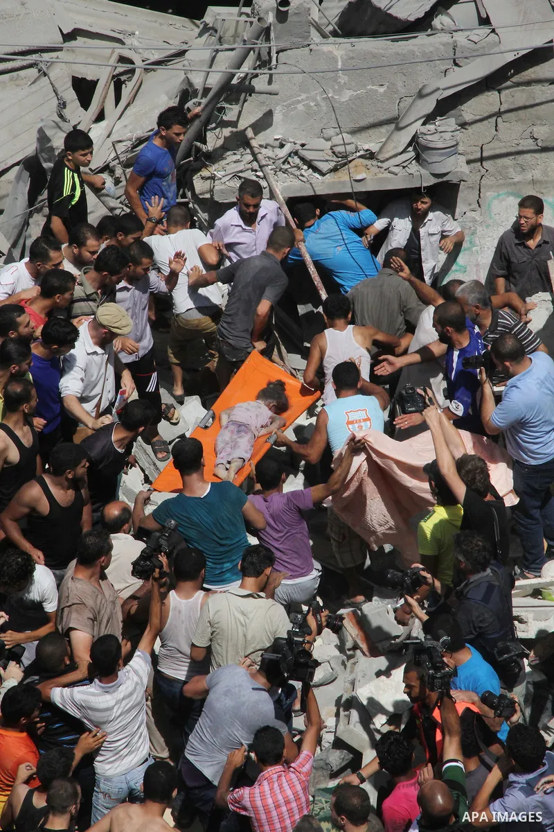 Palestinians carry the body of a girl amidst the rubble of a building after what police said was an Israeli air strike at Shati (Beach) refugee camp in Gaza City August 4, 2014. A seven-hour truce under which Israel woul...