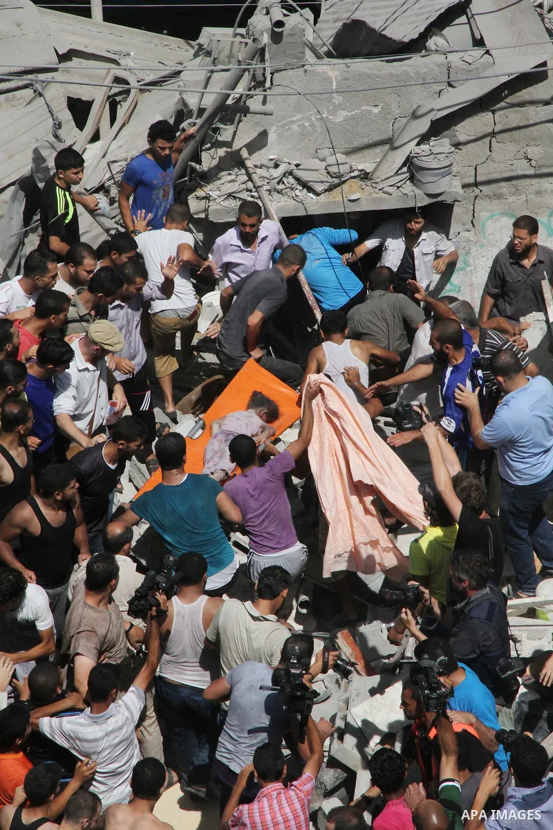 Palestinians carry the body of a girl amidst the rubble of a building after what police said was an Israeli air strike at Shati (Beach) refugee camp in Gaza City August 4, 2014. A seven-hour truce under which Israel woul...