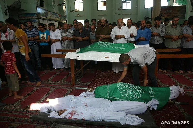 Palestinians look at the bodies of members of the Abu Nejim family, whom medics said were killed by an Israeli air strike, during their funeral in Jabaliya refugee camp in the northern Gaza Strip August 4, 2014. A seven-...