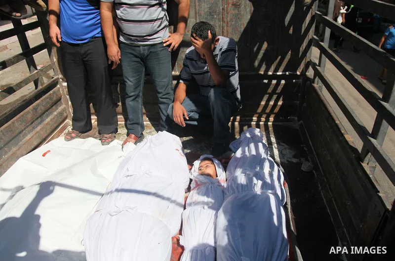 Palestinians look at the bodies of members of the Abu Nejim family, whom medics said were killed by an Israeli air strike, during their funeral in Jabaliya refugee camp in the northern Gaza Strip August 4, 2014. A seven-...