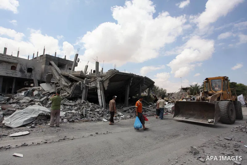 Palestinians walk upon the debris of a house which witnesses said was destroyed in an Israeli air strike, in Rafah in the southern Gaza Strip August 4, 2014. Palestinians accused Israel of breaking its own ce asefire on...