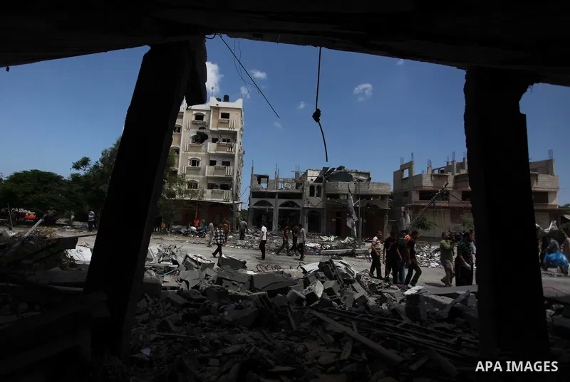 Palestinians gather as rescue workers search for victims under the rubble of a house which witnesses said was destroyed in an Israeli air strike, in Rafah in the southern Gaza Strip August 4, 2014. Palestinians accused I...