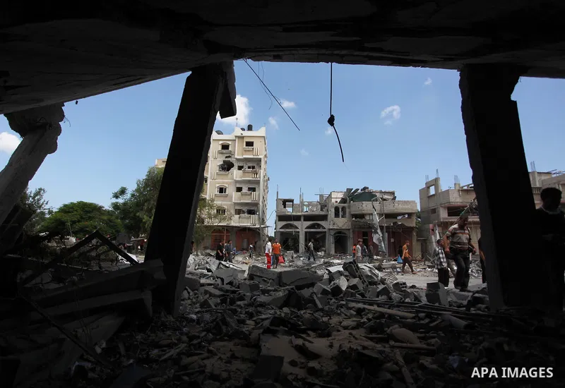 Palestinians gather as rescue workers search for victims under the rubble of a house which witnesses said was destroyed in an Israeli air strike, in Rafah in the southern Gaza Strip August 4, 2014. Palestinians accused I...