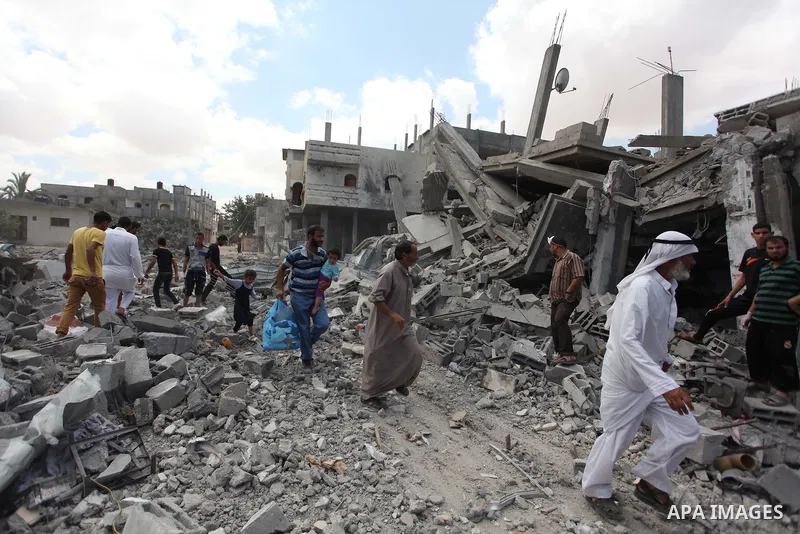 Palestinians walk upon the debris of a house which witnesses said was destroyed in an Israeli air strike, in Rafah in the southern Gaza Strip August 4, 2014. Palestinians accused Israel of breaking its own ce asefire on...