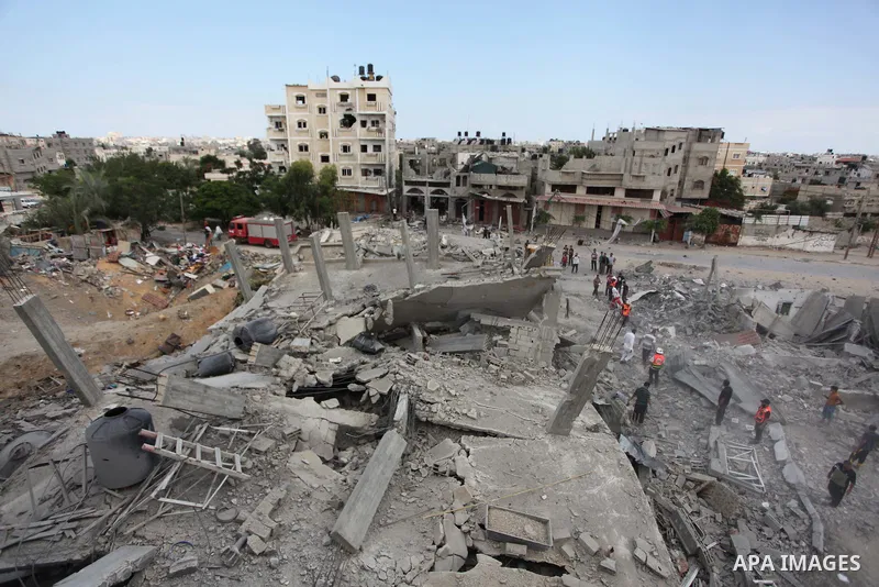 Palestinians gather as rescue workers search for victims under the rubble of a house which witnesses said was destroyed in an Israeli air strike, in Rafah in the southern Gaza Strip August 4, 2014. Palestinians accused I...