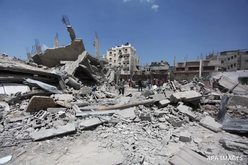 Palestinians gather as rescue workers search for victims under the rubble of a house which witnesses said was destroyed in an Israeli air strike, in Rafah in the southern Gaza Strip August 4, 2014. Palestinians accused I...