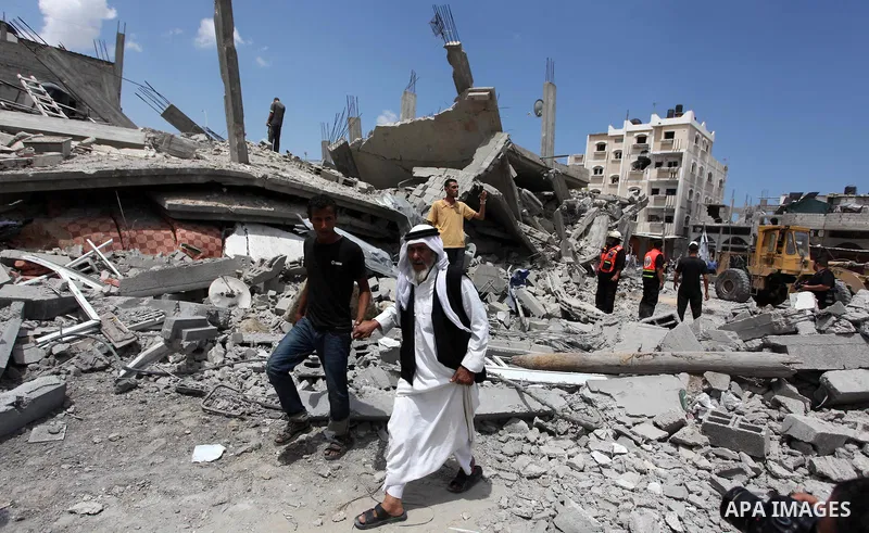 Palestinians walk upon the debris of a house which witnesses said was destroyed in an Israeli air strike, in Rafah in the southern Gaza Strip August 4, 2014. Palestinians accused Israel of breaking its own ce asefire on...