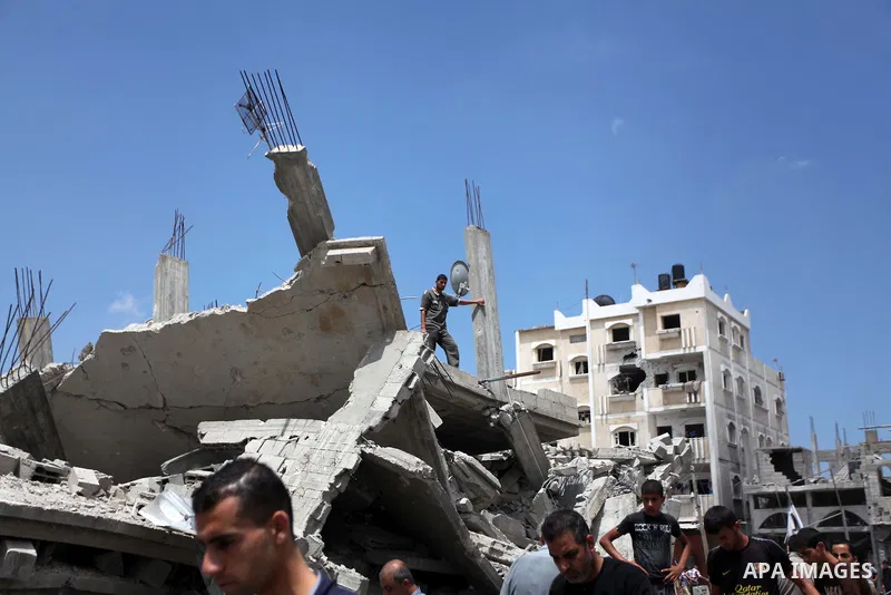 Palestinians walk upon the debris of a house which witnesses said was destroyed in an Israeli air strike, in Rafah in the southern Gaza Strip August 4, 2014. Palestinians accused Israel of breaking its own ce asefire on...