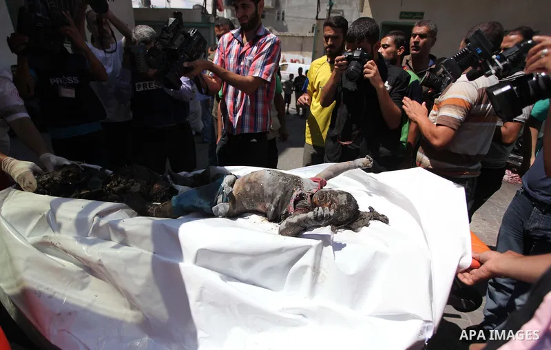 Palestinians carry the dead body of a woman after removing it from under the rubble of a house which witnesses said was destroyed in an Israeli air strike, in Rafah in the southern Gaza Strip August 4, 2014. Palestinians...