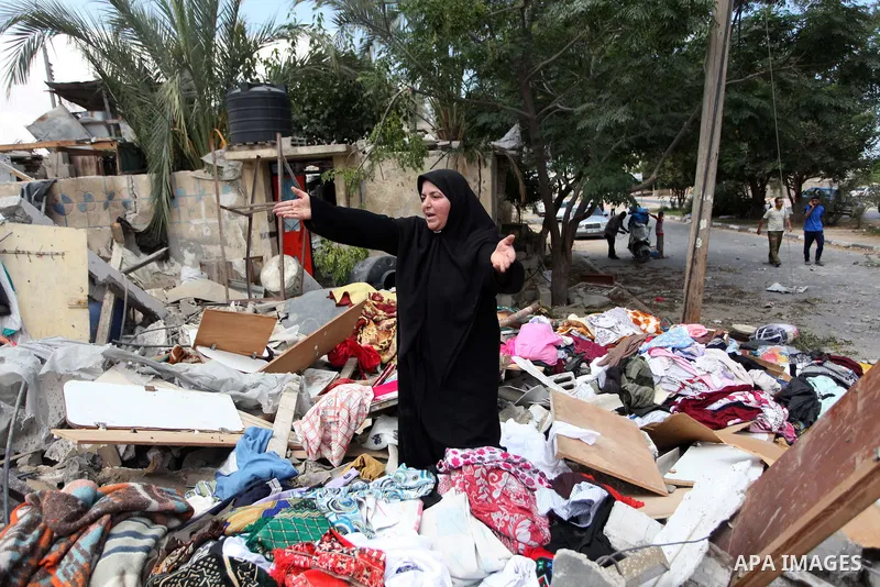 A Palestinian woman reacts as she collects her belongings from her house which witnesses said was destroyed in an Israeli air strike, in Rafah in the southern Gaza Strip August 4, 2014. Palestinians accused Israel of bre...