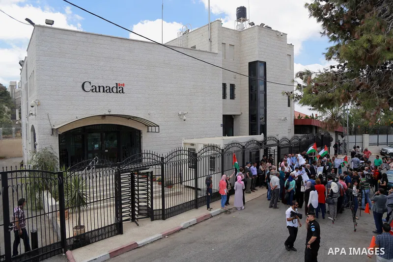 Palestinians hold banners during a protest against the policy of Canada in front of the Canadian Embassy, in the West Bank city of Ramallah, on August 4, 2014. Canada supported for the Israeli aggression on the Gaza Stri...