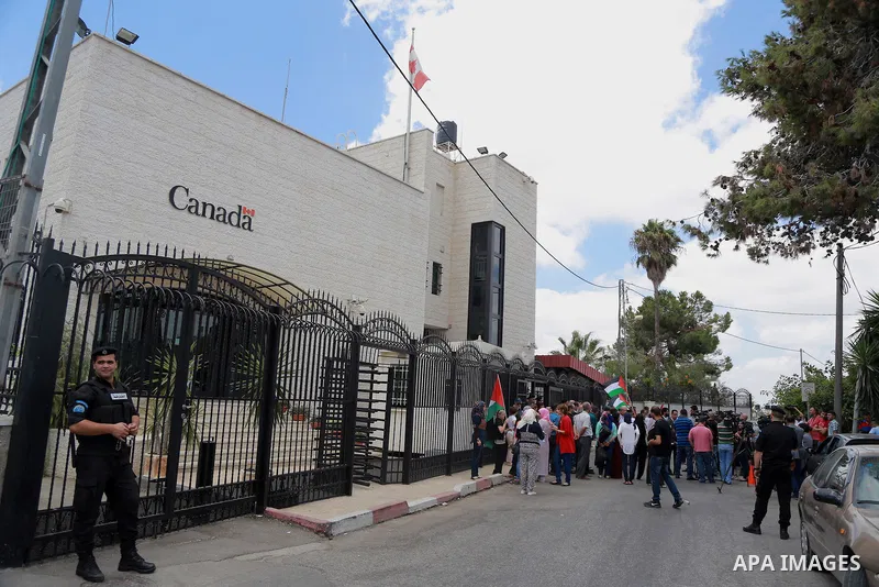 Palestinians hold banners during a protest against the policy of Canada in front of the Canadian Embassy, in the West Bank city of Ramallah, on August 4, 2014. Canada supported for the Israeli aggression on the Gaza Stri...