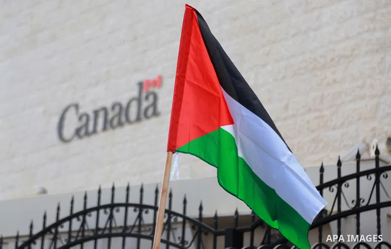 Palestinians hold banners during a protest against the policy of Canada in front of the Canadian Embassy, in the West Bank city of Ramallah, on August 4, 2014. Canada supported for the Israeli aggression on the Gaza Stri...