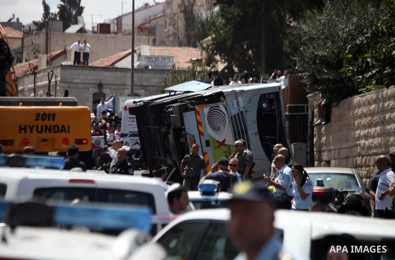 Israeli rescue workers stand near a body at the scene of an attack in Jerusalem, Monday, Aug. 4, 2014. An Israeli-declared cease-fire and troop withdrawals slowed violence in the Gaza war Monday, though an attack on Isra...