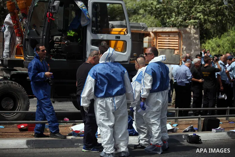 Israeli rescue workers stand near a body at the scene of an attack in Jerusalem, Monday, Aug. 4, 2014. An Israeli-declared cease-fire and troop withdrawals slowed violence in the Gaza war Monday, though an attack on Isra...