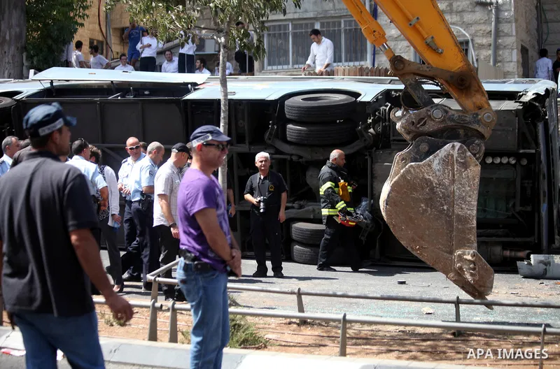 Israeli rescue workers stand near a body at the scene of an attack in Jerusalem, Monday, Aug. 4, 2014. An Israeli-declared cease-fire and troop withdrawals slowed violence in the Gaza war Monday, though an attack on Isra...