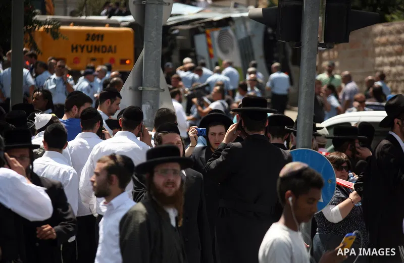 Israeli ultra orthodox Jews watch as Israeli police work at the scene after a Palestinian man rammed an excavator into a bus, on August 4, 2014 in Jerusalem, killing one person and lightly injuring five others. The incid...
